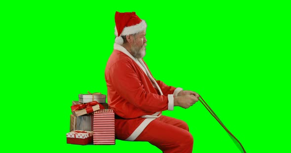 Santa claus with gift box riding on green screen 4k