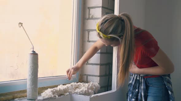 Woman Cleans Frame of Window at Construction in Apartment