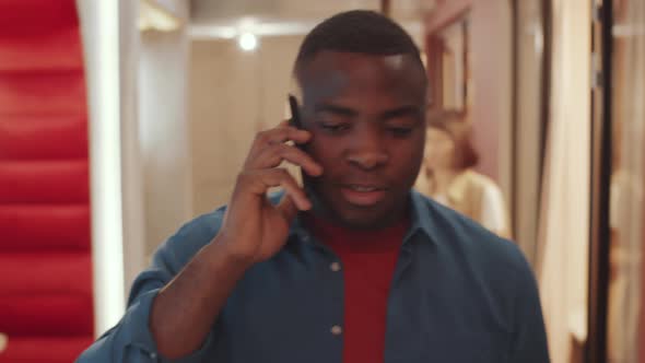 African Man Walking in Coworking Space and Chatting on Phone