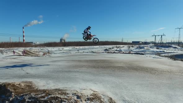 a motorcyclist performs stunts on a winter track