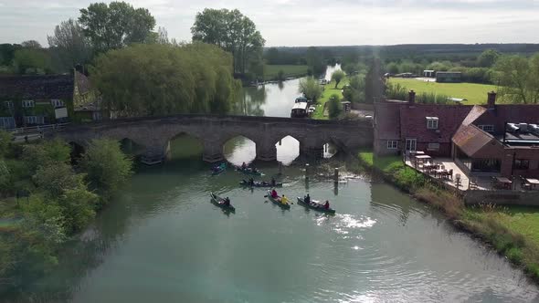 People Kayaking On River Thames Under The Old Stone Bridge In Abingdon Town, Oxford City, UK.- aeria