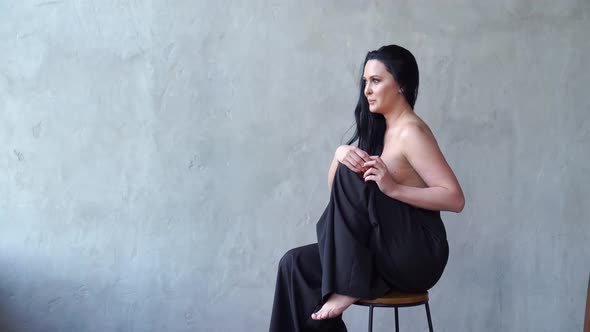 A Beautiful Woman Topless Sitting on a High Chair