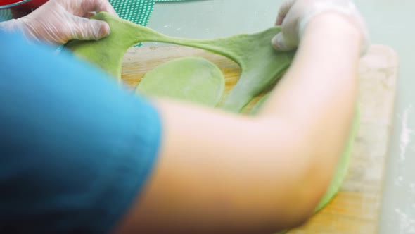 The Chef Forms Round Dough From the Green Dough with a Transparent Bowl