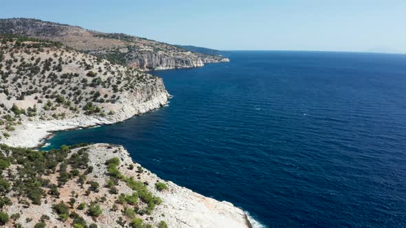 Drone Flying Over Rocky Coast Line with Beautiful Blue Deep Sea Water