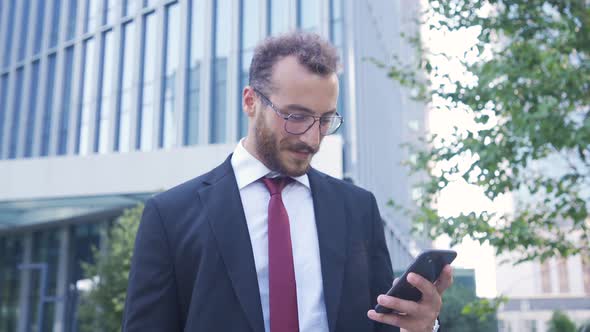 Happy businessman using phone.