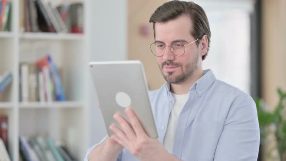Portrait of Man in Glasses Celebrating Success on Tablet