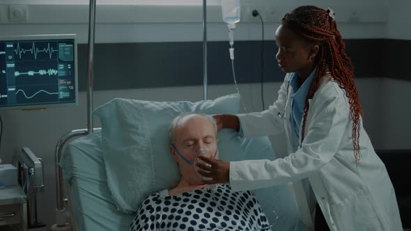 Nurse Consulting Sick Patient in Hospital Ward at Clinic