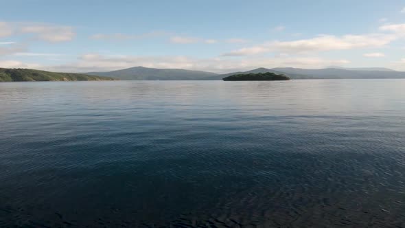 View from a boat on the driving towards a lone island. Marlborough Sounds. Near Picton, New Zealand.