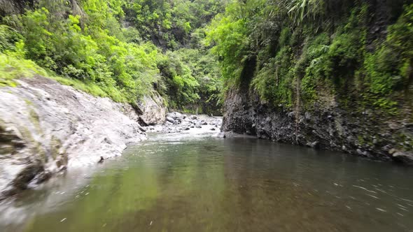 Drone footage of a river and rapids in a green canyon in the Cirque of Mafate on the Reunion island.