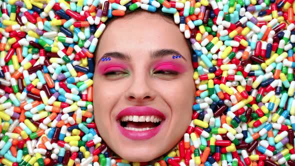 Beautiful girl acting inside a colored background made with pills