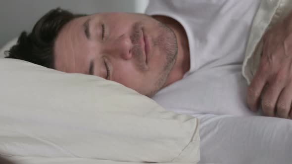 Middle Aged Man Going to Sleep in Bed