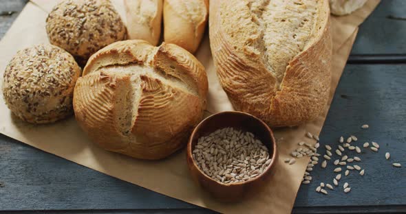 Video of rolls and bread on baking paper on wooden worktop