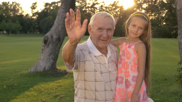 Grandfather and Girl Waving with Hands.