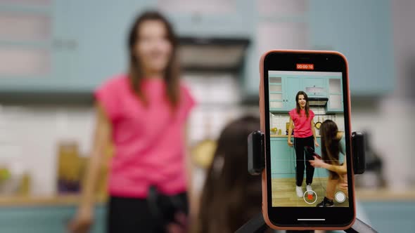 Two Young Girls Dancing Sing Having Fun and Filming Videos for Their Blogs or Social Networks