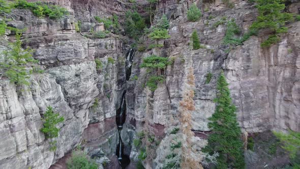 Aerial Into Large Canyon with Tiers of Waterfalls in Background