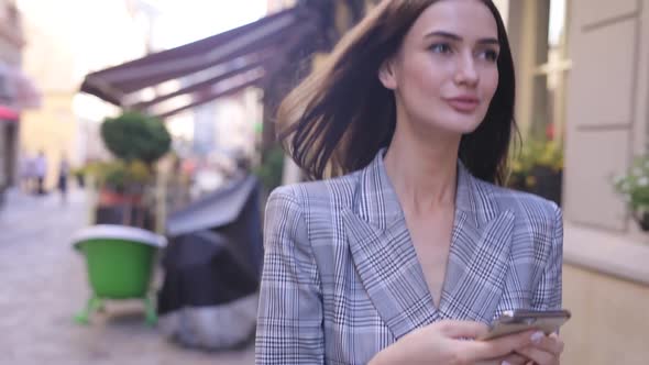 Beautiful Smiling Woman Using Phone Walking On City Street