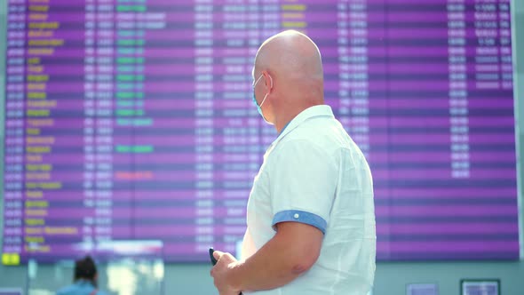 Portrait of Man Wearing Medical Mask at Airport. Air Passenger, Tourist Standing Against Departure