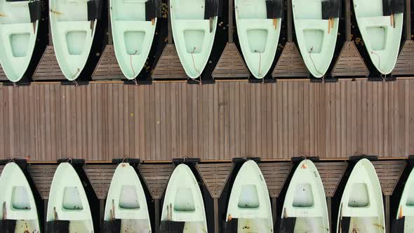 Boats Along Pier on River Strewn with Leaves in Autumn Park