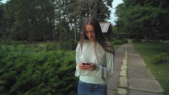 A Girl in a Blouse Goes on the Track in the Park and Becomes the Message