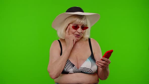 Senior Woman Tourist Browsing on Mobile Phone App Looking for Resort Hotel on Chroma Key Background