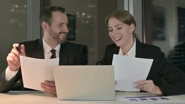 Executive Business People Reading Documents at Night