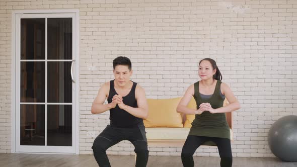 family couple doing YOGA standing meditating on exercise sitting squat