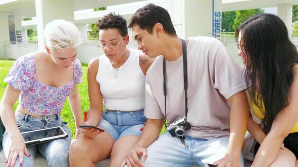 Group of multiethnic young friends outdoors using smartphone