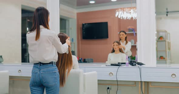 Girl Hairdresser Straightens Hair Model