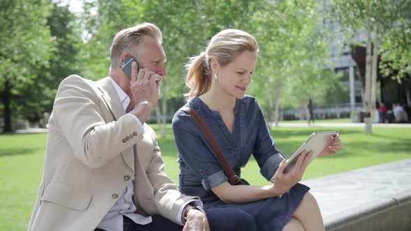 Two colleagues having informal meeting in front of office building