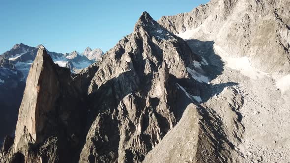 drone aerial view of rocky peaks in the swiss alps during a sunrise