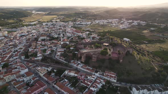 Sunset view of Silves Castle and sprawling Silves city, Algarve. Orbiting shot