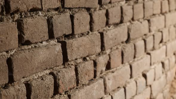 Old building wall details shallow DOF slow-tilt 4K 2160p 30fps UltraHD footage - Rows of clay bricks
