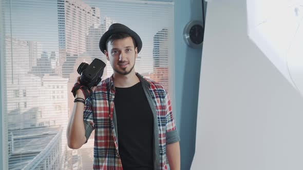 Smiling Young Photographer Posing with His Professional Camera