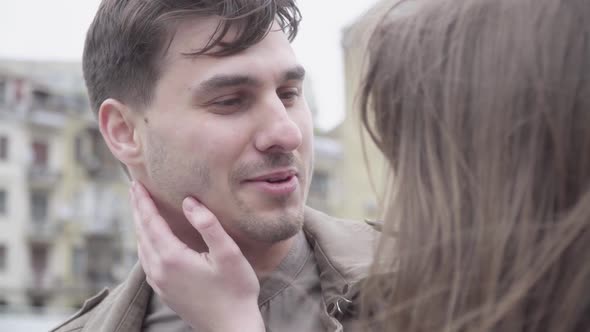 Close-up of Handsome Young Man Talking To Girlfriend Touching His Face. Happy Caucasian Boyfriend