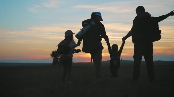 Silhouettes of Father, Mother and Children Hiking. Hiking Backpackers Trekking Mountains Summer