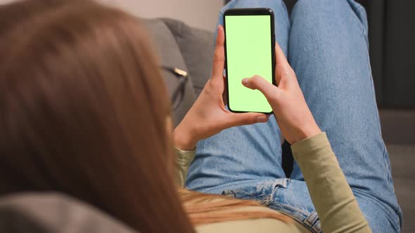 Woman lying on a couch with Green Screen Smartphone