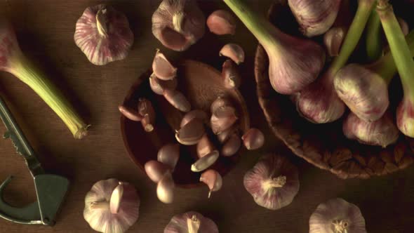 Super Slow Motion Plate with Garlic Falls on Gray Background