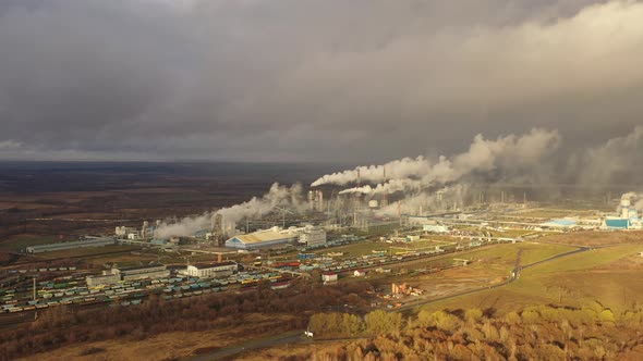 White Smoke Comes Out of a Large Number of Tall Chimneys of Chemical Plants Against the Backdrop of