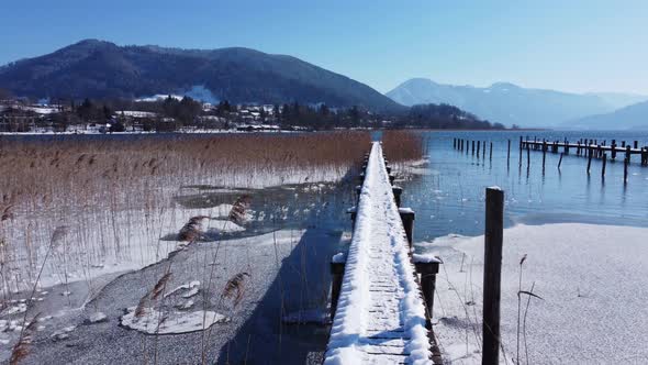 Snow covered dock in a mountain lake. Snow covered jetty in the lake Tegernsee.