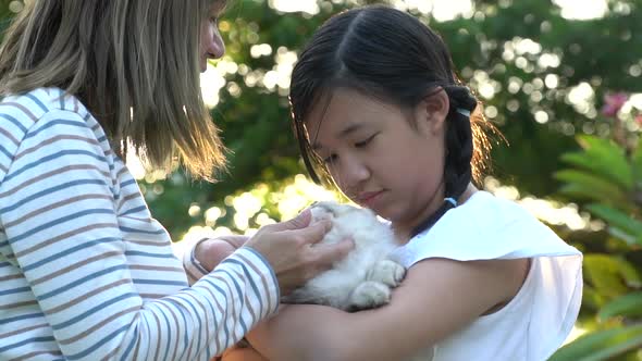 Asian Mother Playing A Kitten To Her Daughter 