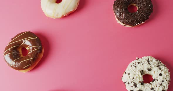 Video of donuts with icing on pink background