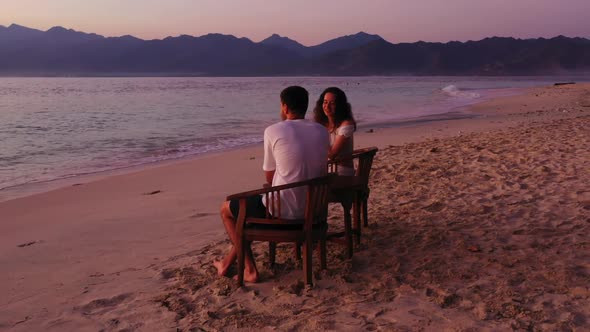 Man and woman posing on relaxing island beach trip by shallow sea and white sand background of Gili 