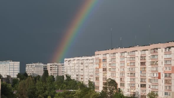 Huge Rainbow in the Cloudy Sky Above the Houses in City