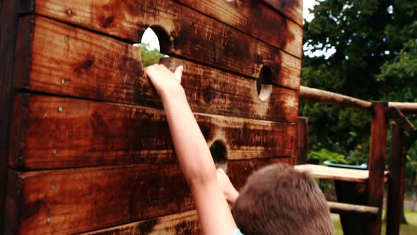 Boy climbing on a playground ride in park