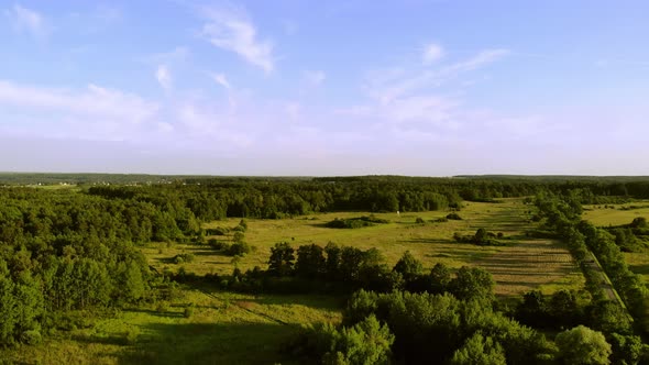 The road leads through fields and forests.