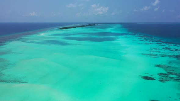 Aerial above sky of tranquil island beach vacation by blue lagoon with white sand background of a pi