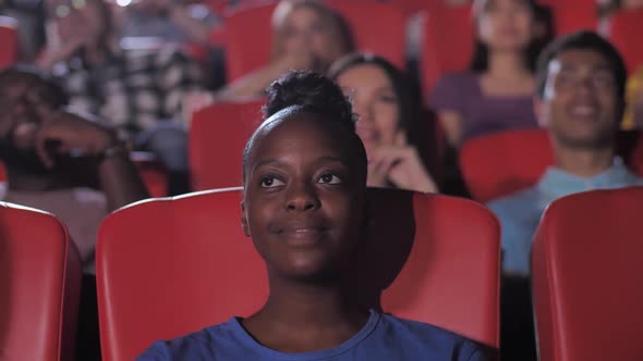 Happy Dark-skinned Woman Watching Comedy in Cinema