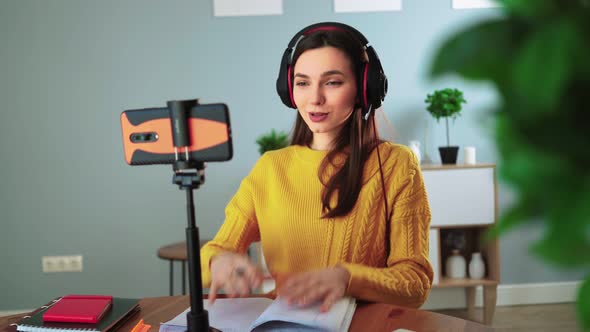 Happy Young Teacher in Headphones Communicates By Video Call Using Mobile Phone