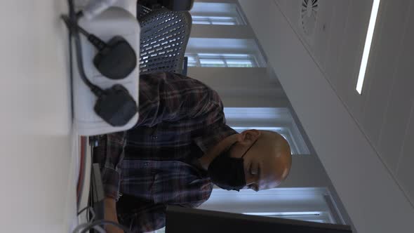 Smart Casual Adult Male Wearing Face Mask Using Computer In Office. Low Angle, Vertical Video, Locke