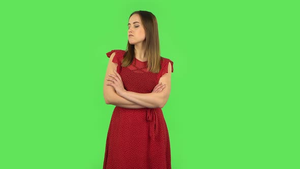 Tender Girl in Red Dress Is Standing Offended and Then Smiling. Green Screen